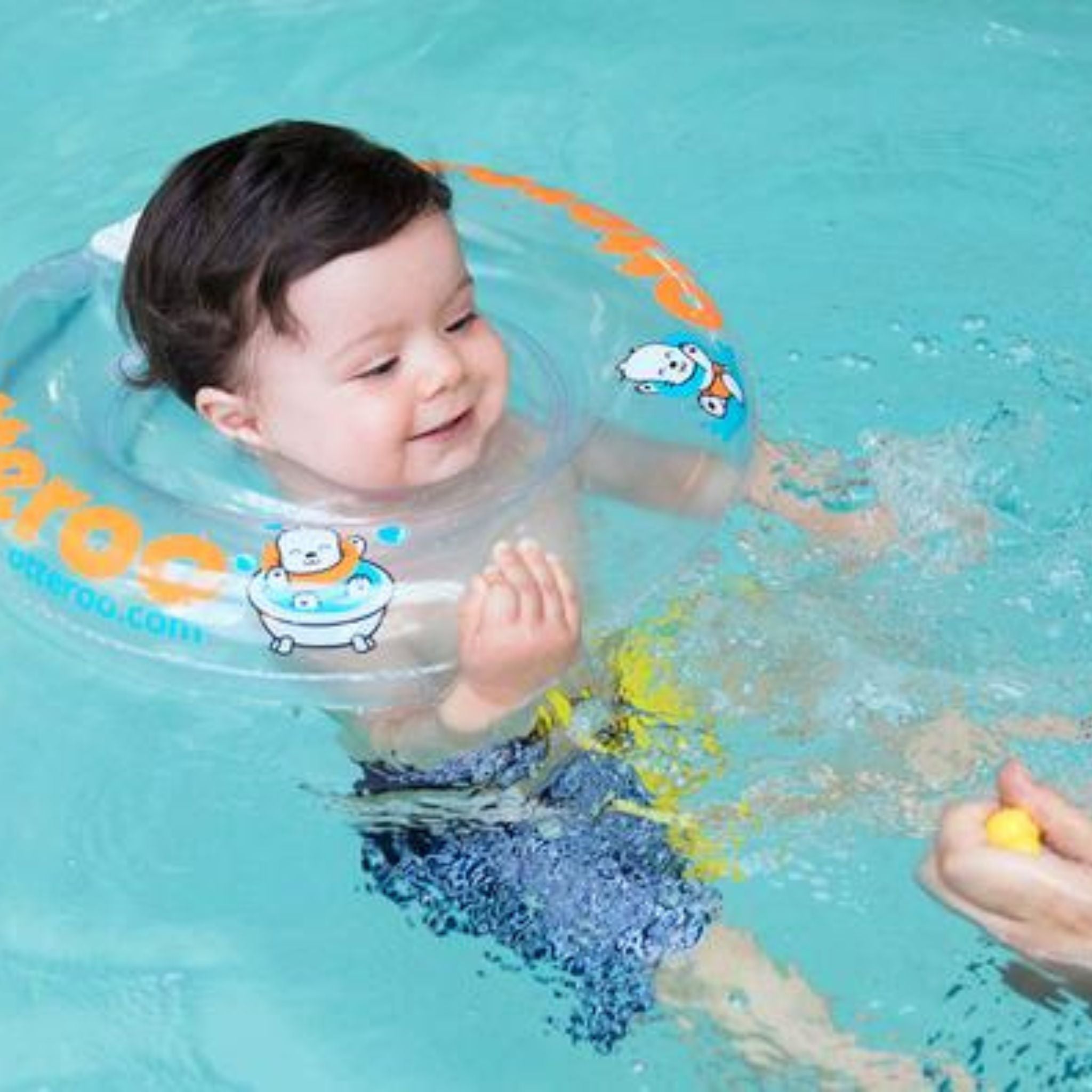 baby boy wearing Otteroo baby neck float in pool playing with parent