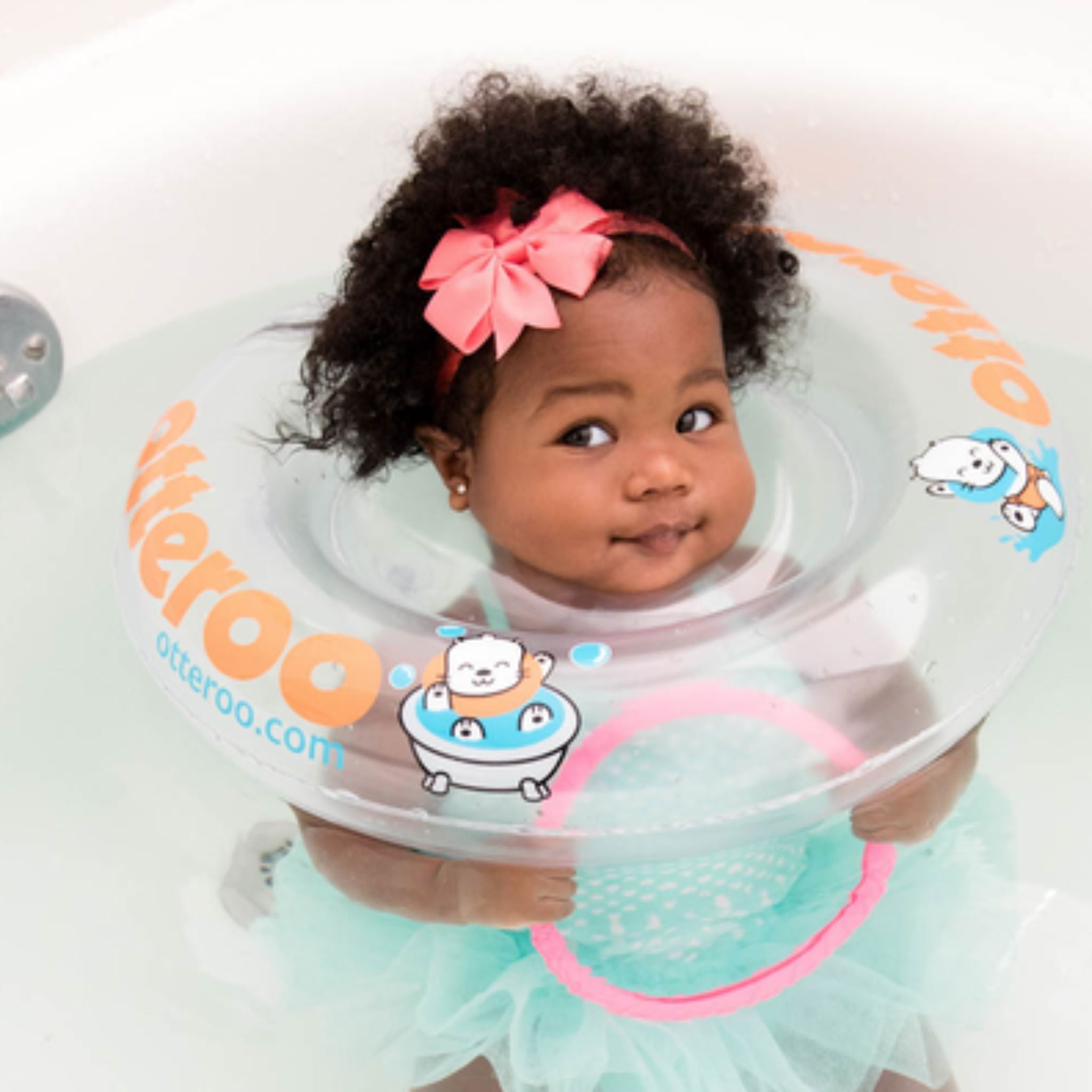 baby girl wearing Otteroo baby neck float in bath tub holding toy