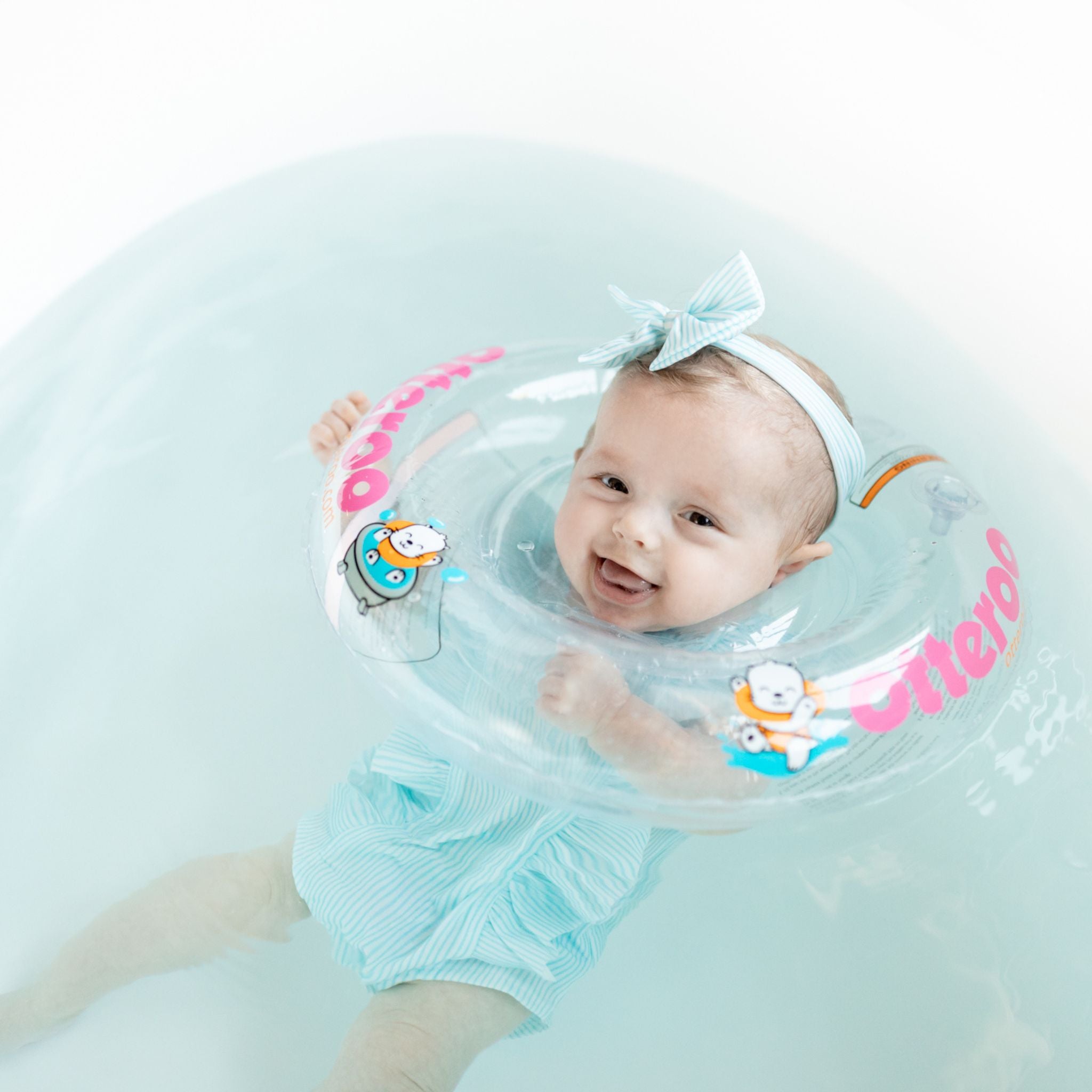 baby girl wearing Otteroo MINI baby neck float in pink